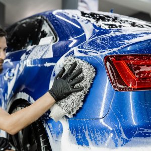 car-washer-doing-manual-foam-washing-auto-detailing-service-hand-washing-with-microfiber-glove-with-foam-car-body-garage-scaled.jpg